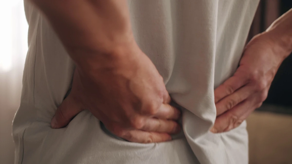 someone holding their aching back.