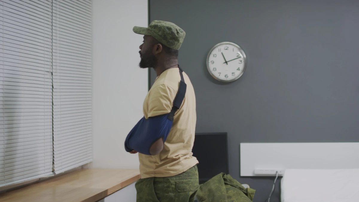 A man in a waiting room with his arm in a sling