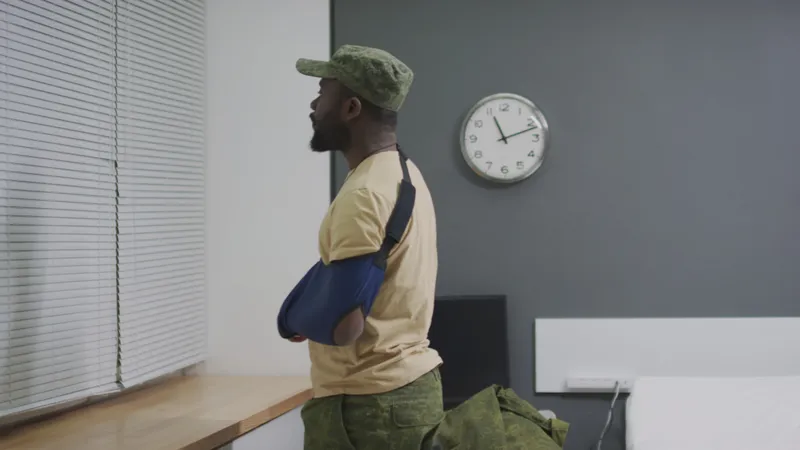 A man in a waiting room with his arm in a sling